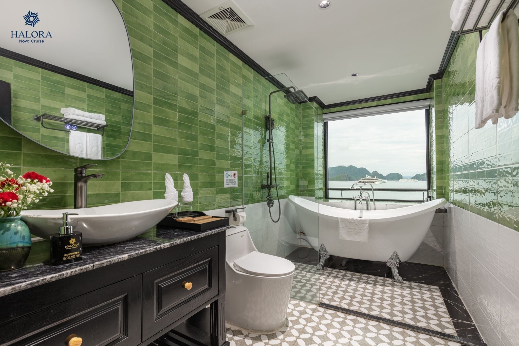 A bathroom with a large window, a bathtub, a sink, and a toilet.