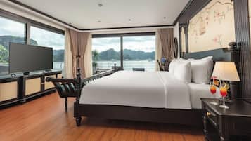 Une chambre d’hôtel avec un grand lit, une télévision et une vue sur un plan d’eau.
