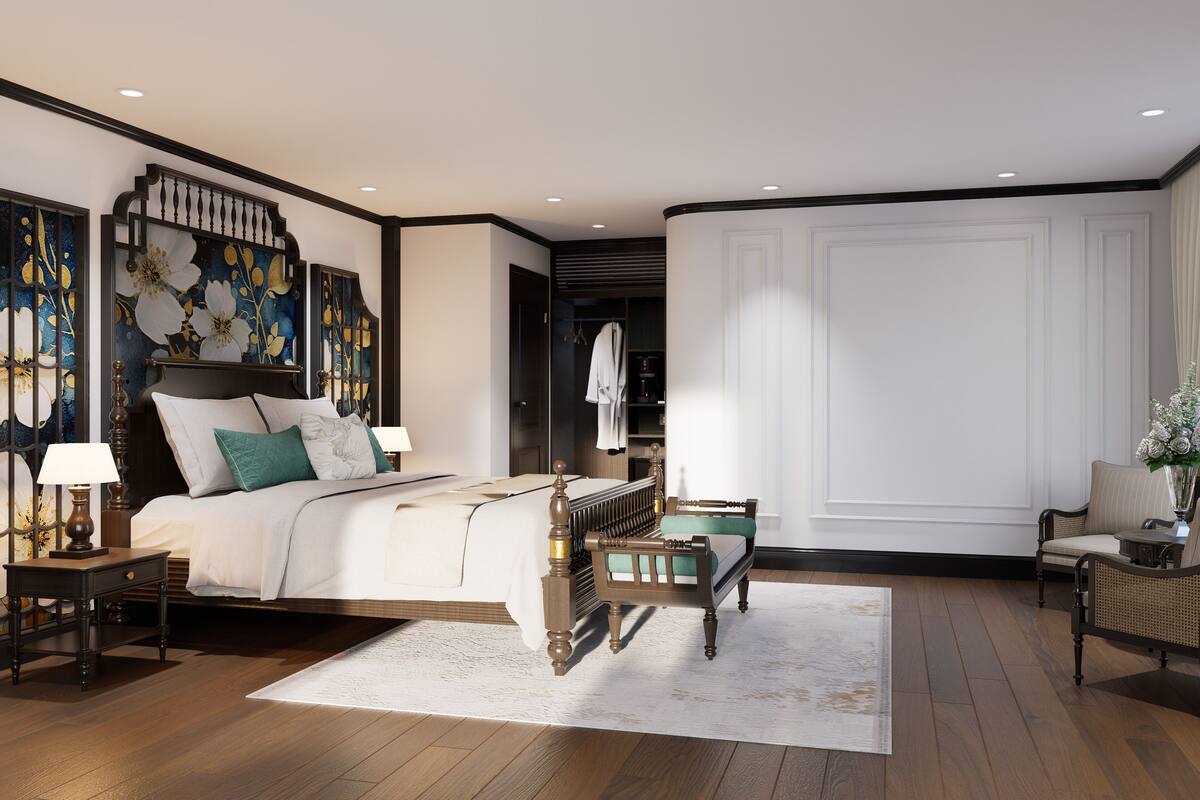Un dormitorio con una cama grande, una mesita de noche, una silla y un adorno en la pared.