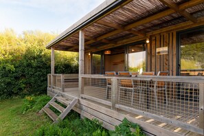 A wooden deck with outdoor seating and a covered area.