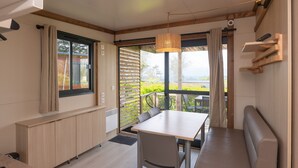 Une cuisine moderne avec un coin repas, un banc et une vue sur l’extérieur.