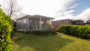 Une maison mobile moderne dotée d’un porche abrité, d’un petit escalier et d’une pelouse bien entretenue.