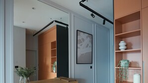 A modern interior with a wooden counter, a mirror, a framed artwork, and a wooden floor. - Madera (Čačak)