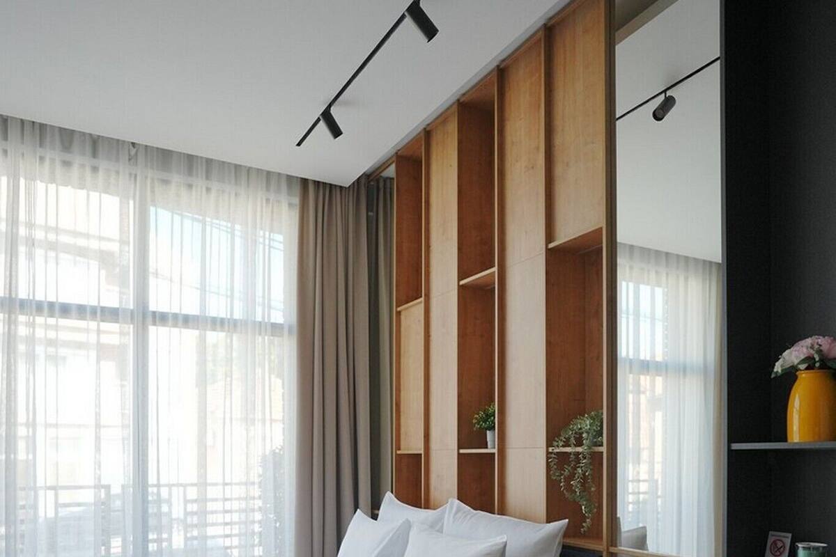 Una habitación de hotel moderna con una cama grande, una mesita redonda y una zona de estar.