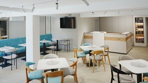 A modern interior with seating areas, tables, and a counter.