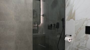 A modern bathroom with a glass-enclosed shower, marble walls, and a black toilet.