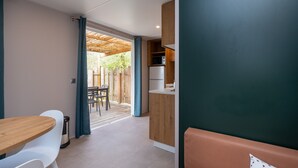 A modern kitchen with a microwave, refrigerator, and wooden cabinets. - Mobile Home "Au vert du jardin" 500m from the Beach (Plouhinec)
