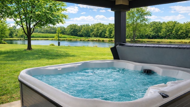 Uma banheira de hidromassagem com vista para um lago e árvores.