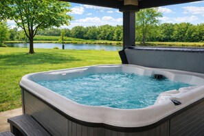 Un jacuzzi con vistas a un lago y árboles.