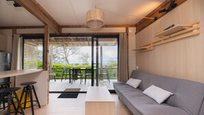 Uma sala de estar moderna com um sofá, uma mesa de centro e uma área de jantar com banquetas.