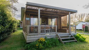 A modern, single-story house with a covered porch, a small kitchen, and a fenced outdoor area. - Chalet "35 m² - Molène" in Plouhinec, 5 Guests, 2 Bedrooms (Plouhinec)