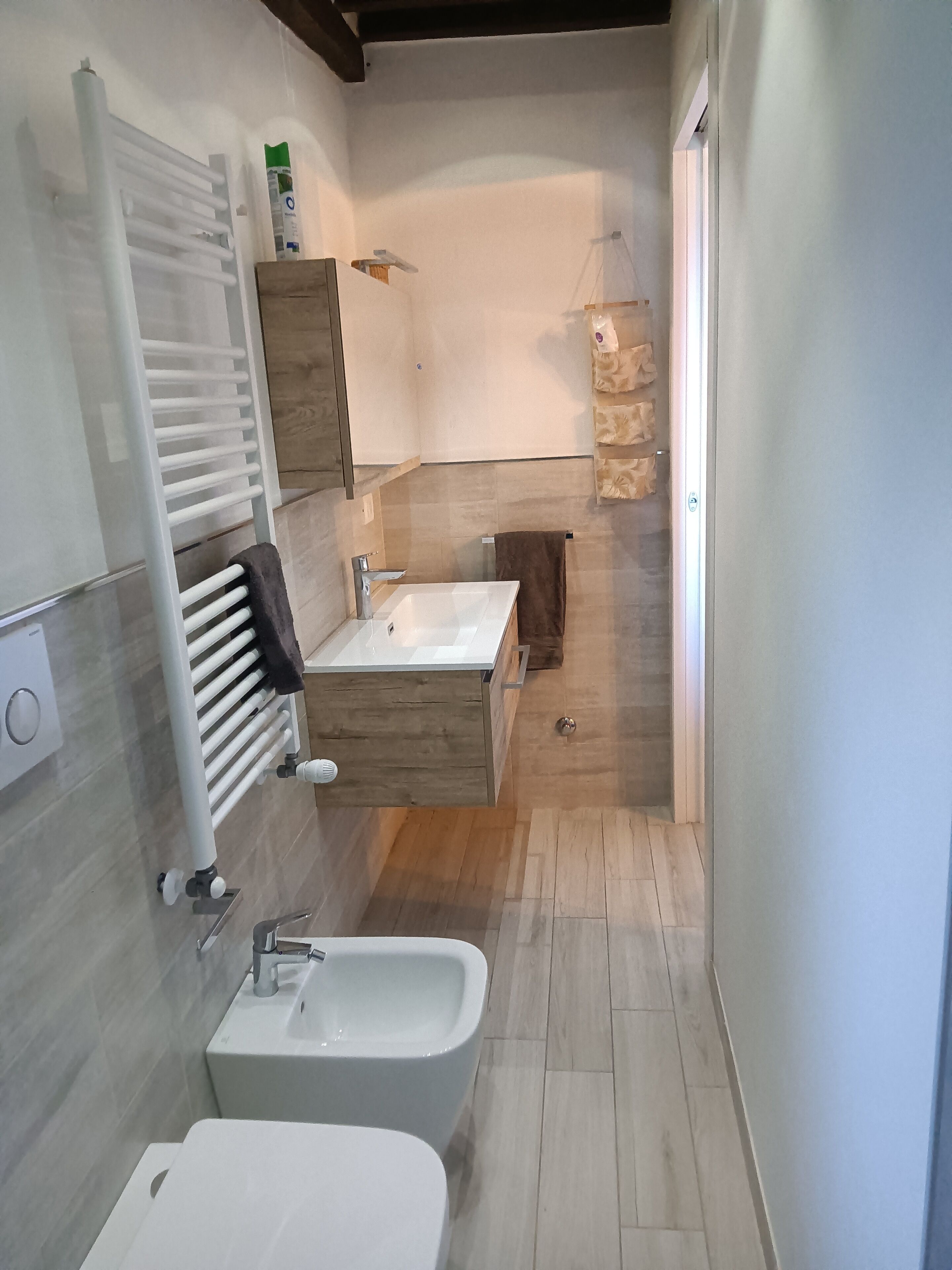 Un bagno moderno con vasca da bagno integrata, un mobile vanitario con specchio e un porta asciugamani.