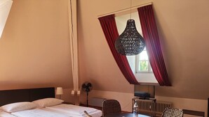 Una camera da letto con un letto, un tavolino rotondo e una sedia.