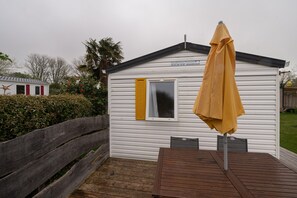 Un pequeño edificio blanco con una ventana y un toldo amarillo.