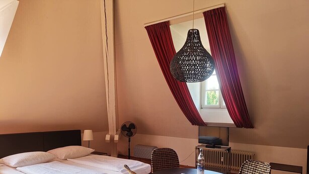 Un dormitorio con una cama, una mesa redonda y una silla.