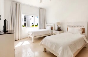 A hotel room with two beds, a desk, a lamp, and a TV. - Primera Línea de Playa. Acceso a Playa, 2 piscinas (Punta Cana)