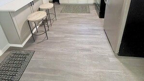 A compact kitchen with white cabinets, a stainless steel refrigerator, a coffee maker, and a small bar stool. - Crewe Corner <br>Apartment C (Crewe)