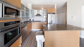 Una cucina moderna con elettrodomestici in acciaio inossidabile, mobili in legno e un piano di lavoro in granito.