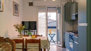 A compact living space with a dining area, a kitchen, and a balcony.