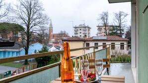 A balcony with a bottle of Prosecco and glasses of water and strawberries.