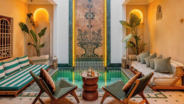 A spacious interior with a high ceiling, a central decorative wall, and a seating area with a patterned floor. - Luxury Taj Riad Zitoune (Marrakech)