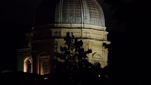 Una gran estructura amb forma de cúpula i un rellotge, sota una lluna plena.