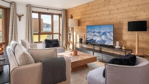 Un soggiorno moderno con una parete in legno, un televisore grande e un divano.