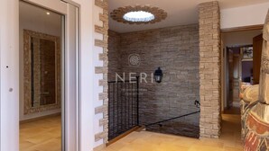 A spacious hallway with a stone wall, a black gate, and a decorative ceiling light. - Villa AMBRA - 6 bedrooms, panoramic sea view, swimming pool (ALBITRECCIA)