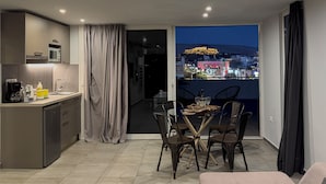 A modern apartment with a kitchen, dining area, and balcony with city views. - Acropolis Magical View Suite, Metro Kerameikos (Athens)