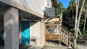 A building with a blue door, an air conditioning unit, and a wooden deck. - Fisherman's Paradise!  50' Concrete Dock. Space for 2 boats (Big Pine Key)