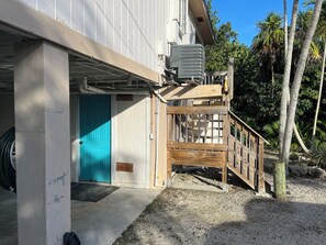 A building with a blue door, an air conditioning unit, and a wooden deck. - Fisherman's Paradise!  50' Concrete Dock. Space for 2 boats (Big Pine Key)