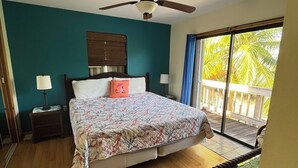 A bedroom with a bed, a ceiling fan, a window with a view of palm trees, and a wooden floor. - Fisherman's Paradise!  50' Concrete Dock. Space for 2 boats (Big Pine Key)