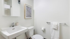 Ein Badezimmer mit einem weißen Waschbecken, einer Toilette und einem Handtuchhalter.