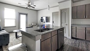 A modern kitchen with granite countertops, stainless steel appliances, and dark wood cabinets. - Landing | Amazing 1BD, Clubhouse, Gym (Manor)