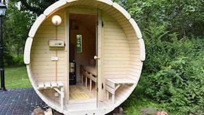 A circular wooden structure with a bench inside, a door, and a small window. - Comfortable holiday home, pool, sauna, jacuzzi (Sasino)