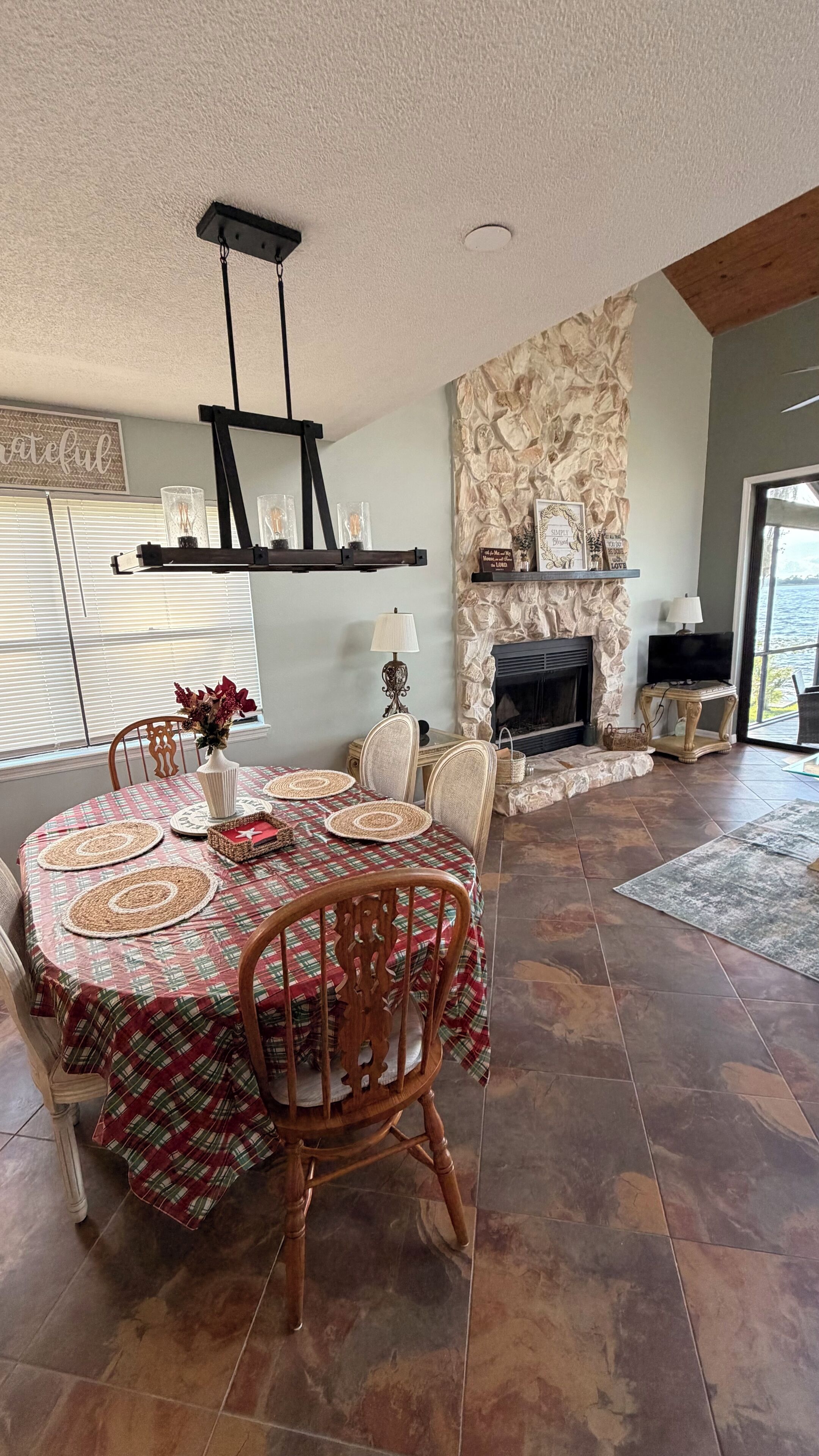 A dining area with a round table, chairs, and a fireplace.