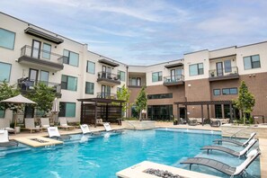 Ein modernes Gebäude mit Pool, Außenbereich und überdachter Terrasse.