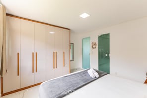 A bedroom with a bed, a wardrobe, and a bathroom door. - House w/ Grill in Front of the Beach Lbra0011 (Ilhéus)