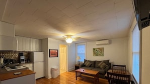 A compact living space with a kitchenette, a dining area, and a seating area. - Gulf Stream House - Unit 12 (Hammondsport)