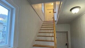 A staircase with wooden steps and a handrail, leading to a door at the top. - Gulf Stream House - Unit 12 (Hammondsport)