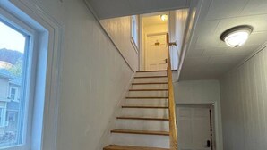 A staircase with wooden steps and a wooden handrail leading to a door at the top. - Gulf Stream House - Unit 11 (Hammondsport)