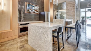 A modern kitchen with a marble countertop, a built-in oven, and a large mirror. - Landing | Beautiful 2BD, Pool, Clubhouse (San Antonio)