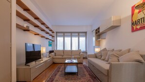 A modern living room with a TV, sofa, coffee table, and a decorative rug. - The Billiards Flat by Wonderful Italy (Turin)