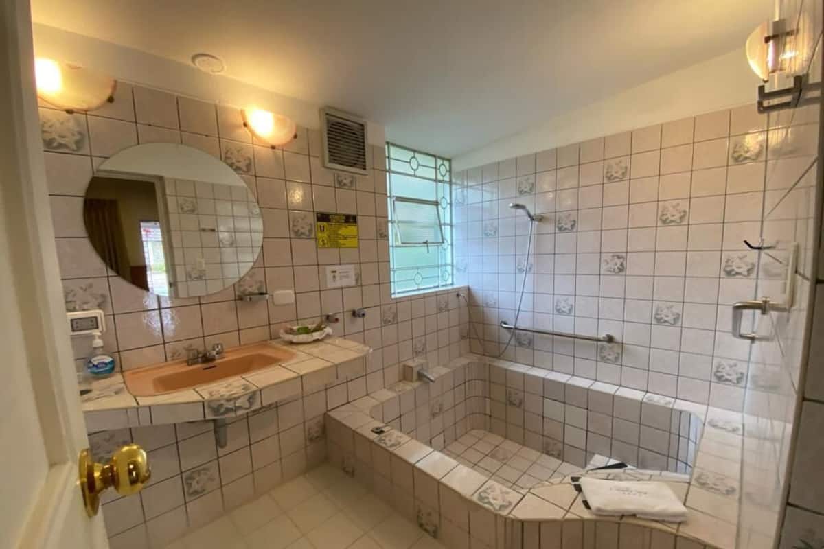 A bathroom with a sink, mirror, shower, and a bathtub.