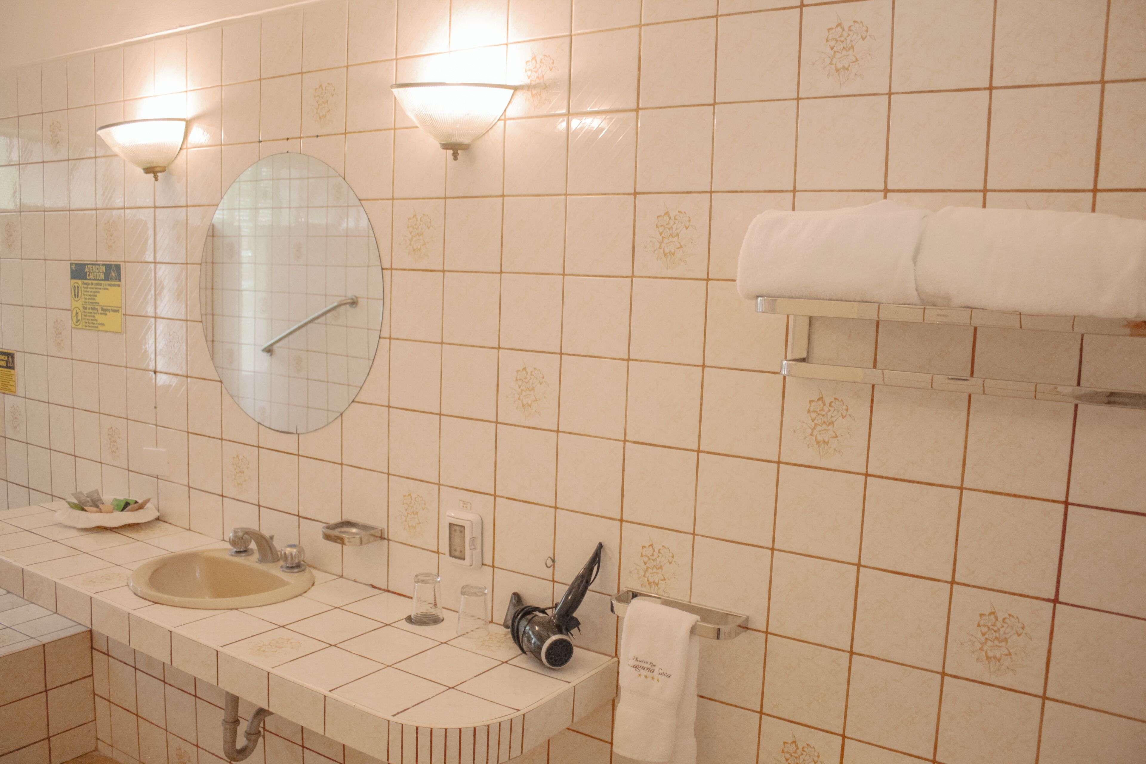 Baño con lavamanos, espejo y toallero.