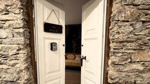 Habitación de paredes de piedra con una cama y un letrero que dice 'Albergarda'.