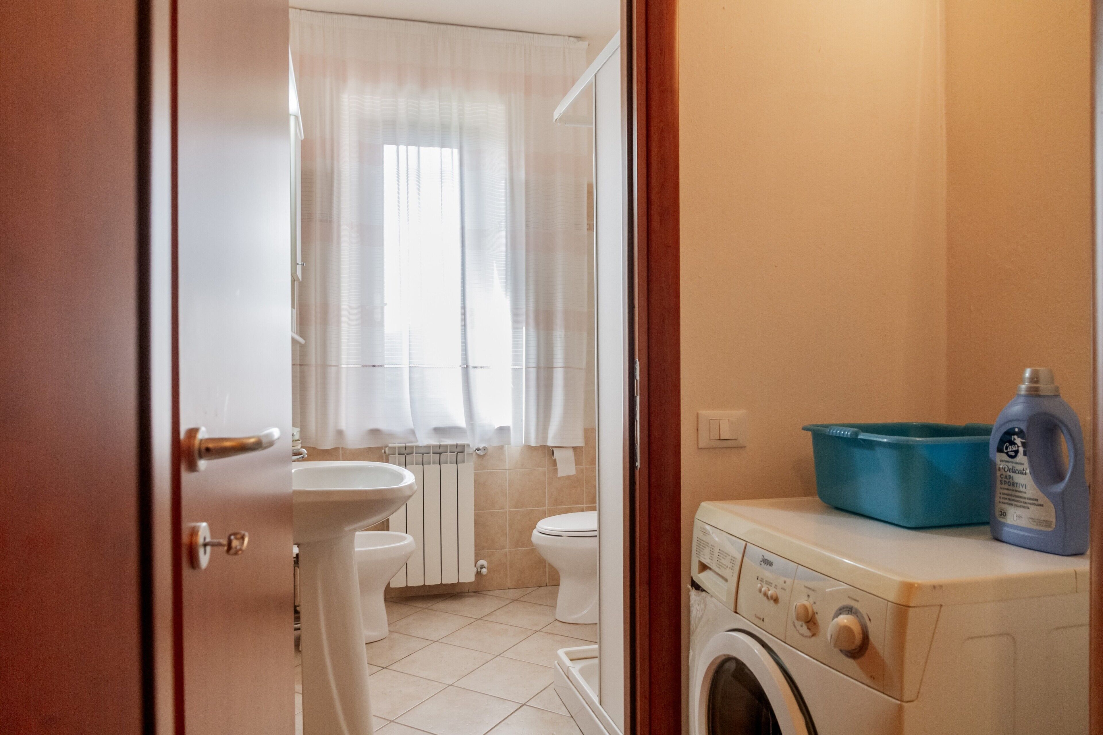 Une salle de bain équipée de toilettes, d’un lavabo et d’un lave-linge.