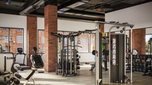 A gym with various exercise equipment, brick columns, and large windows. - Landing | Amazing 1BD, Courtyard, Clubhouse (St. Louis)