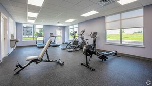 Kuntosali, jossa on juoksumattoja, kuntopyöriä ja penkki.