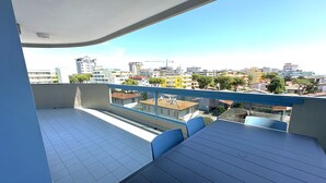 Ein Balkon mit Fliesenboden und einem Tisch mit Stühlen.